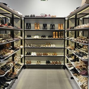 Explore a well-organized shoe store aisle displaying various styles and sizes of modern footwear on shelves.